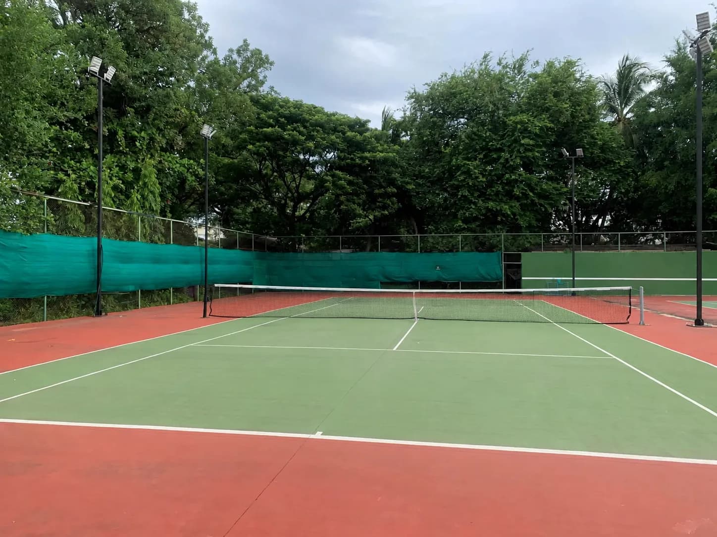 Players on outdoor hard courts at Nawarat Tennis Courts near Chiang Mai Old City